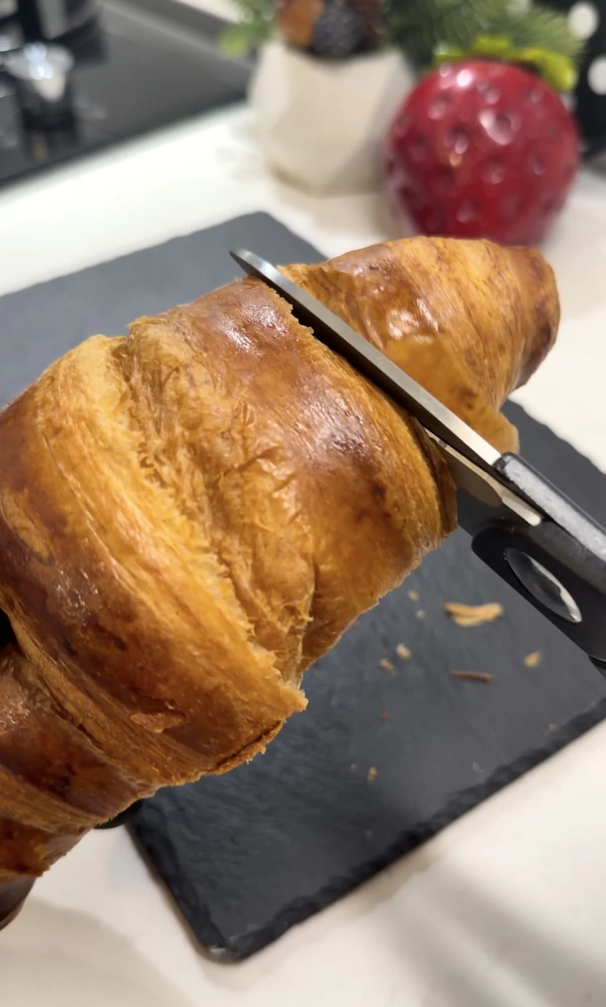 Croissant being cut through the middle