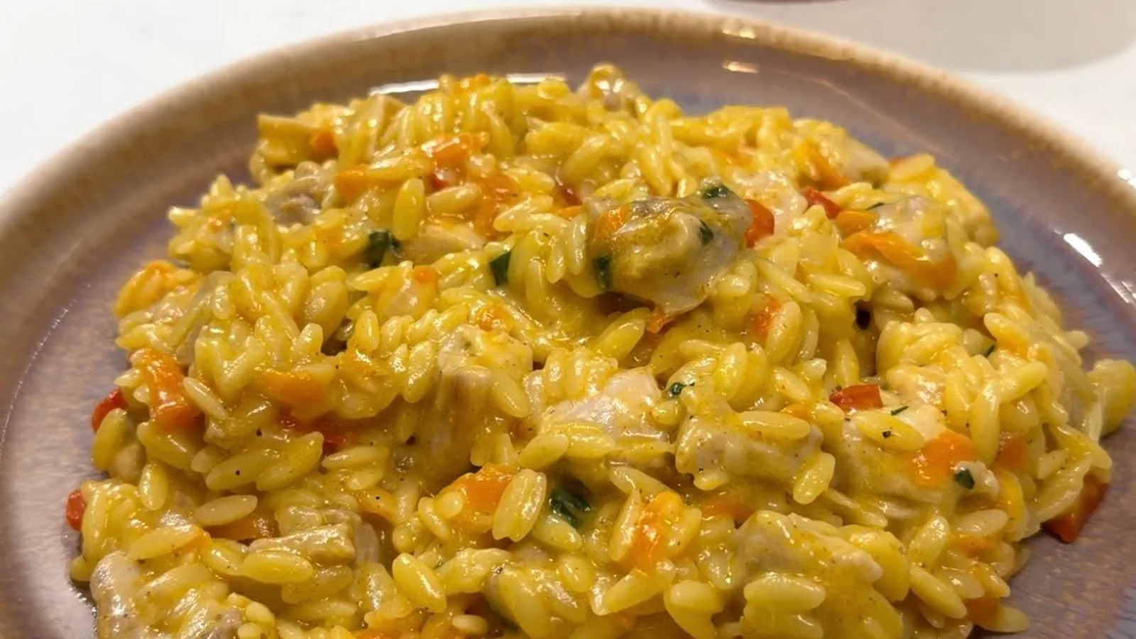 Creamy chicken orzo pilaf served on a plate