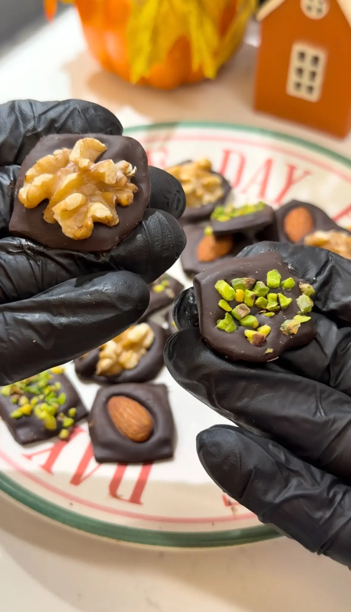 Homemade dark chocolate snacks topped with walnuts almonds and chopped pistachios