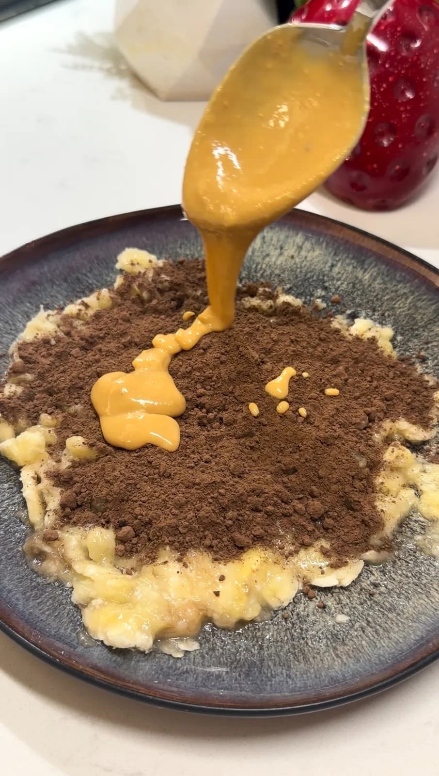 peanut butter poured over mashed banana and cocoa powder