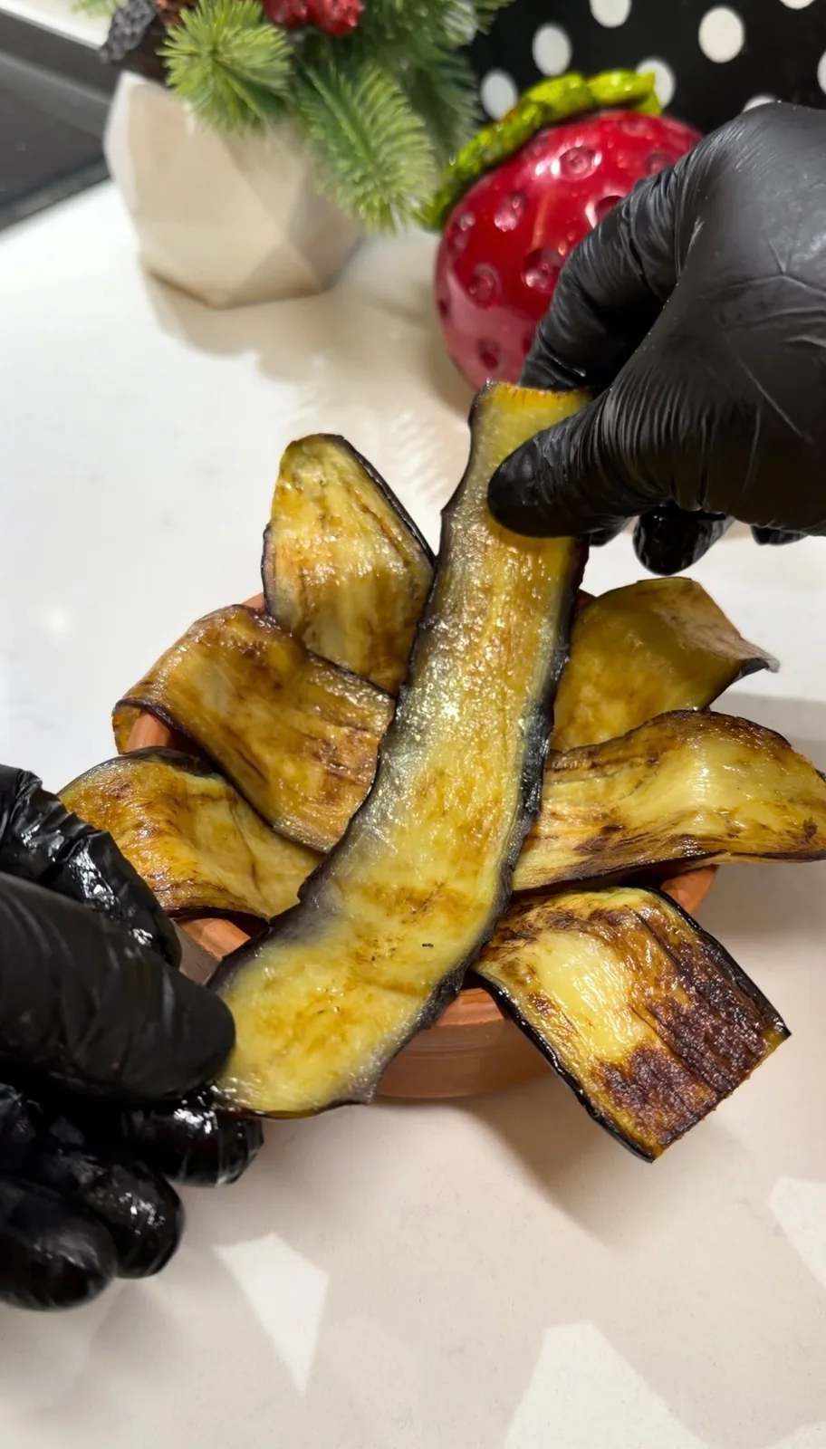 golden fried eggplant slices arranged around a baking dish