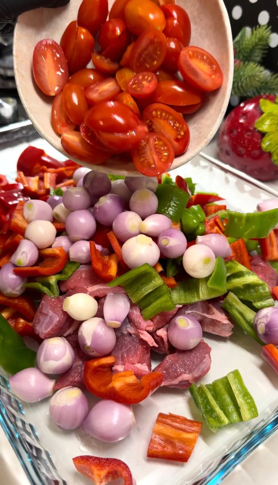 beef, shallots, tomatoes and peppers arranged in a baking dish for Belen Tava