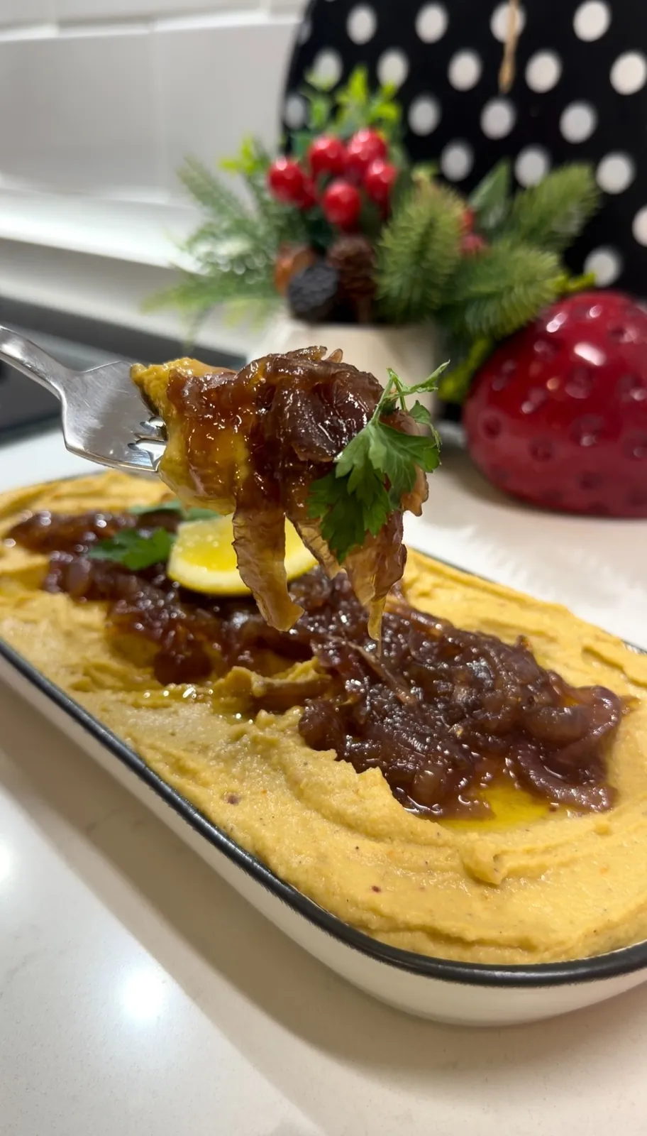 Creamy homemade hummus topped with caramelized red onions and fresh parsley