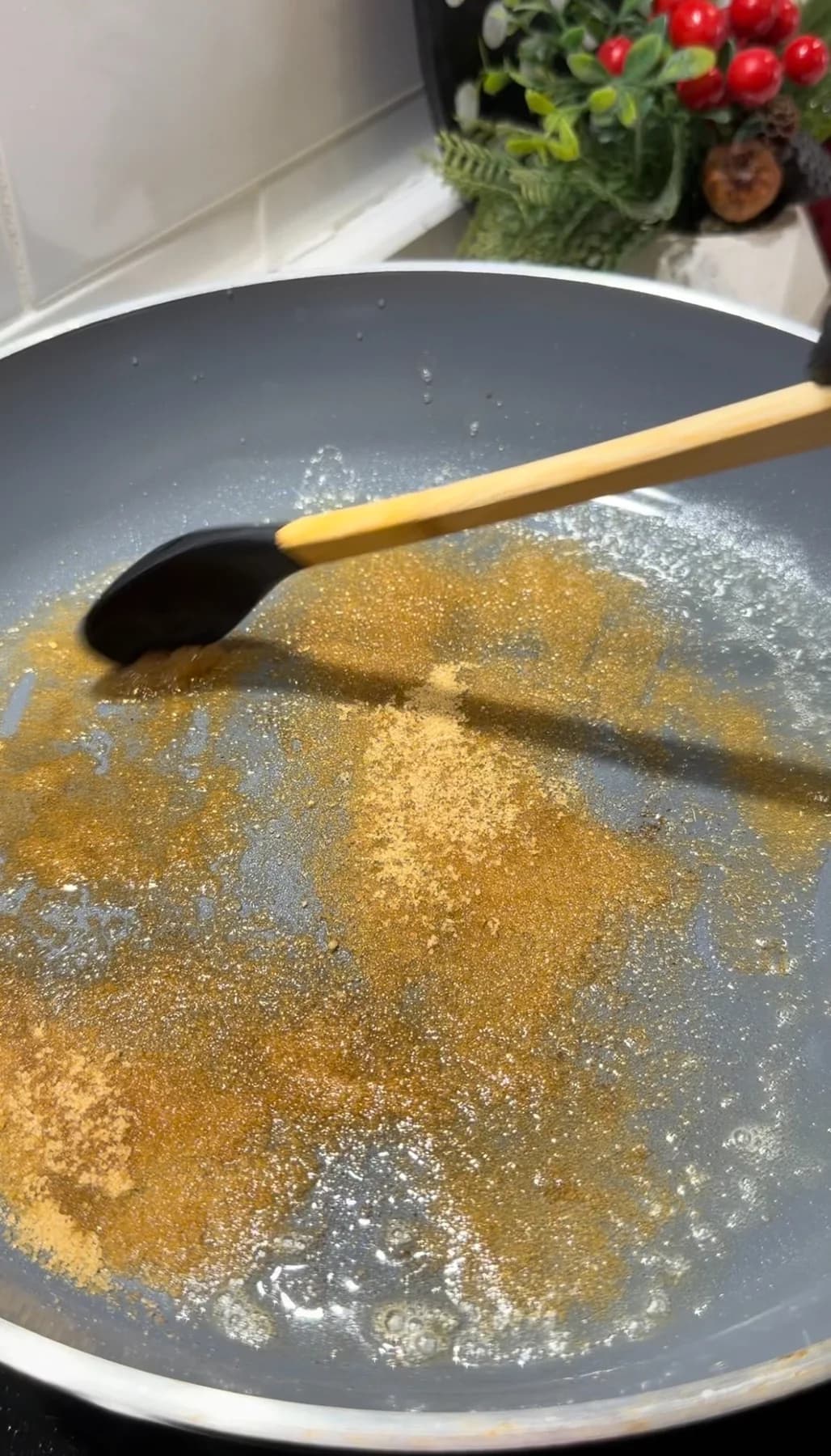 Brown sugar being stirred into melted butter in a skillet