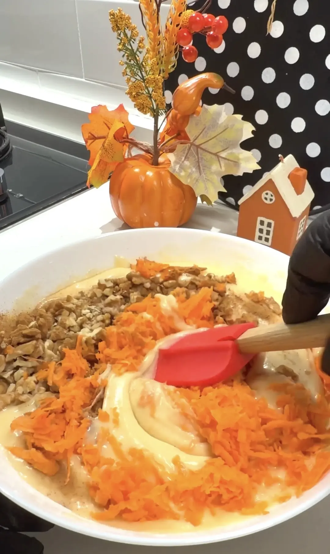 Carrots and walnuts being folded into homemade cake batter