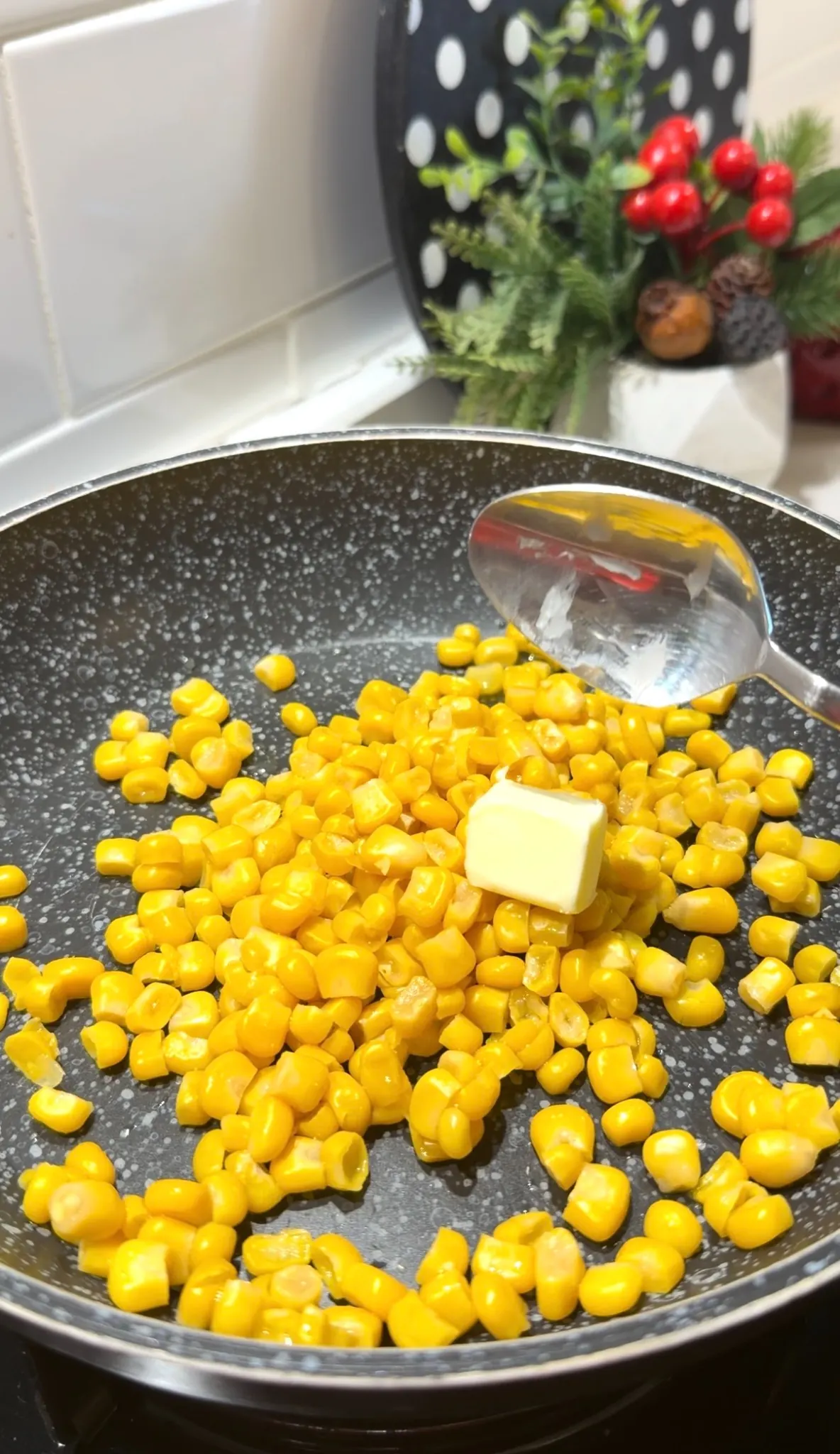 Canned corn and butter cooking together in a skillet