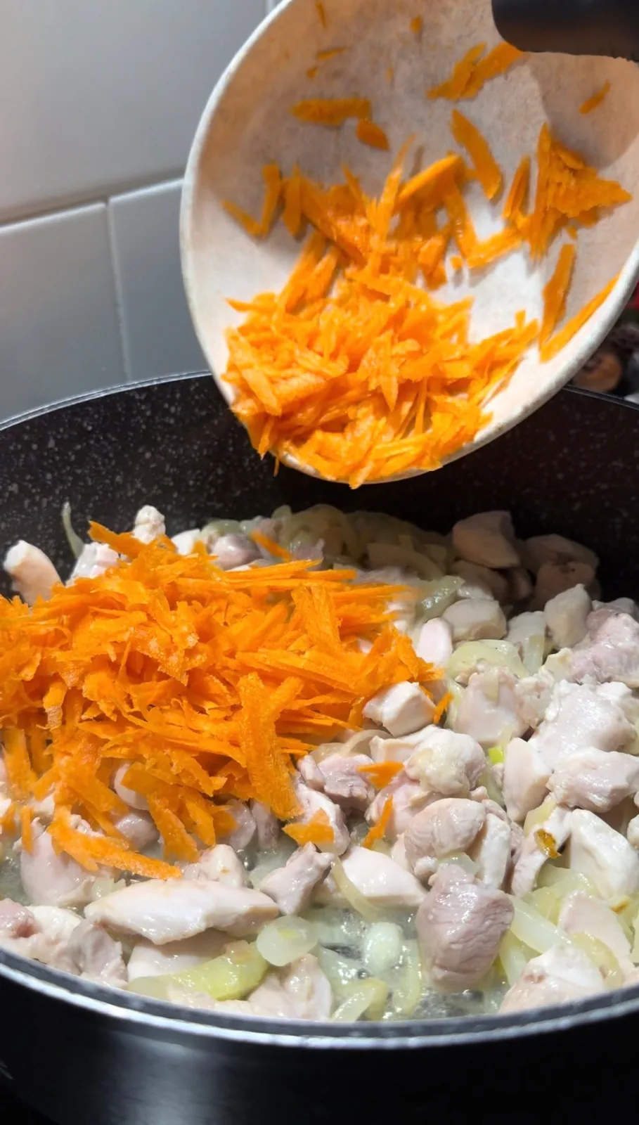 grated carrot added to chicken and onion for one pot chicken orzo pilaf