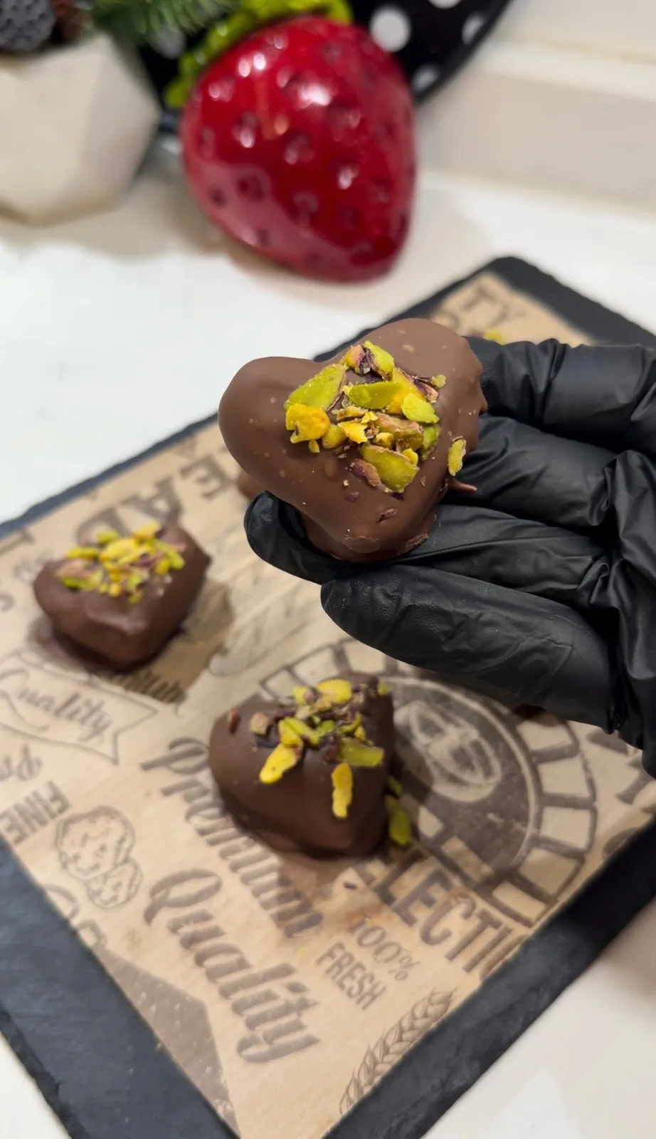 finished chocolate covered date with almond filling and pistachio topping