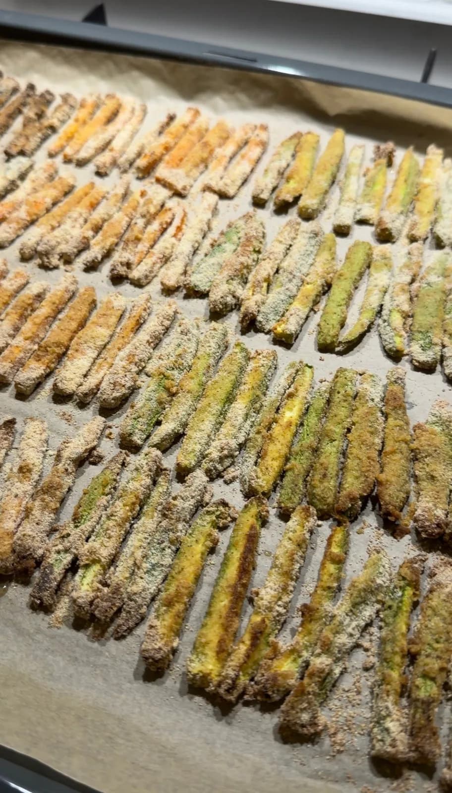 breaded zucchini eggplant and carrot fries arranged on a baking tray