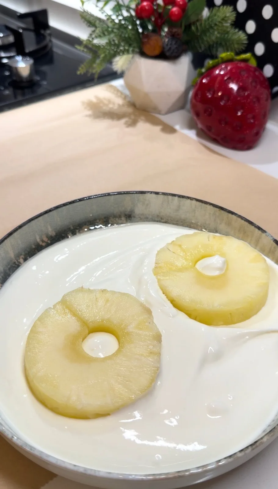 pineapple pieces being coated in thick yogurt for frozen yogurt bites