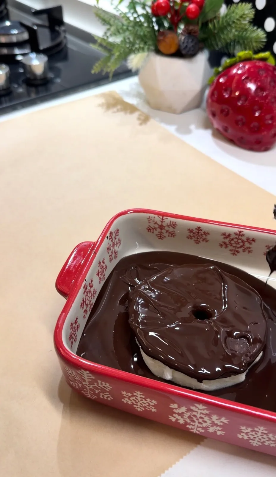 frozen yogurt pineapple piece being dipped in melted dark chocolate