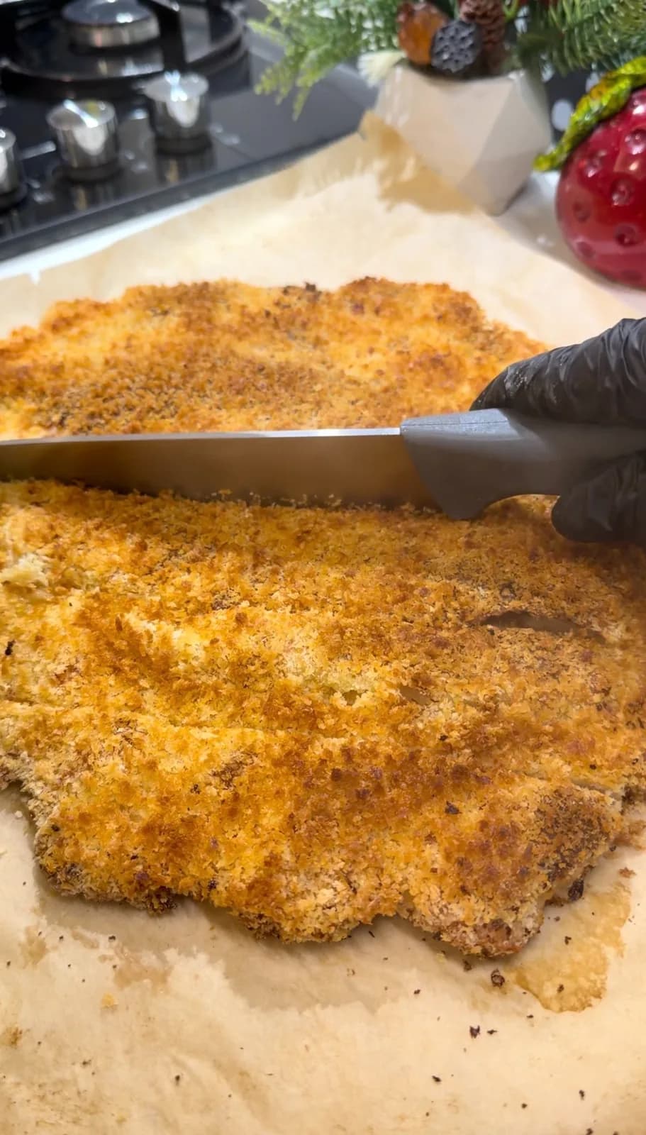 golden oven-baked giant chicken schnitzel being sliced after baking