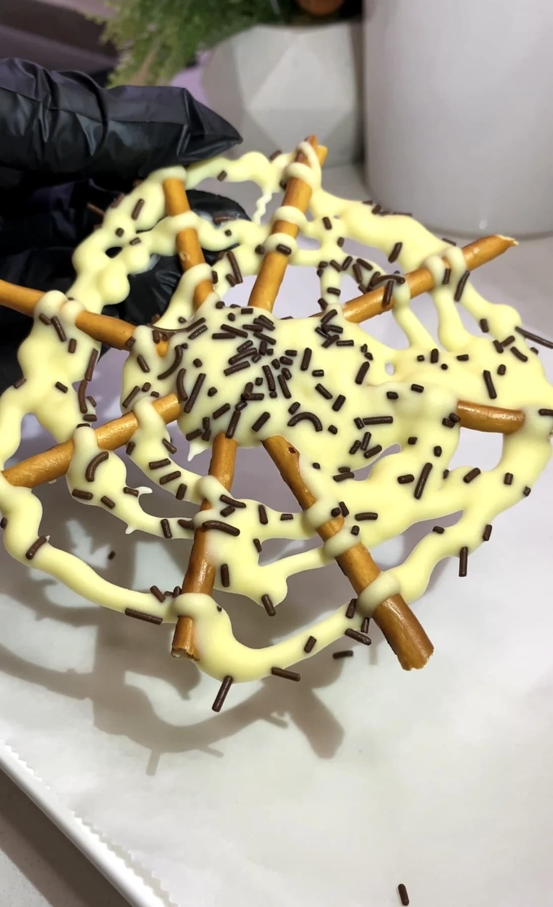 Finished Halloween spider web pretzel covered with white chocolate and chocolate sprinkles