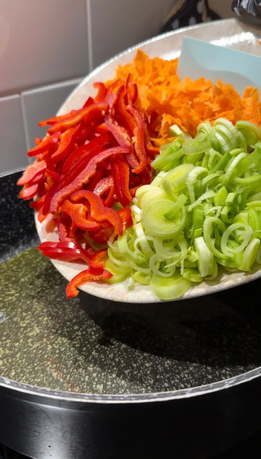 sliced leek and red pepper with grated carrot for healthy vegetable pancakes