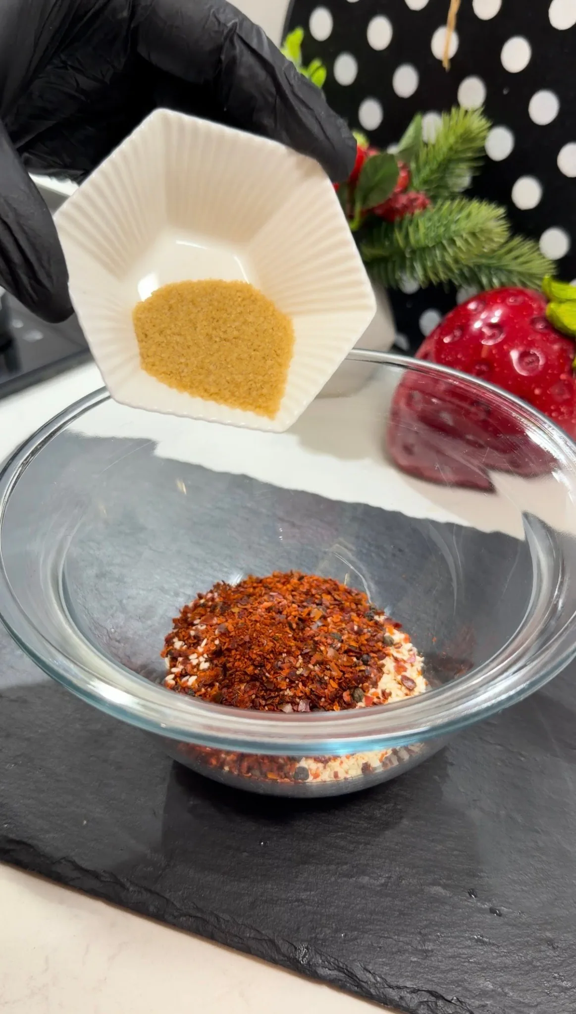 Hot sunflower oil being poured over chili flakes and spices