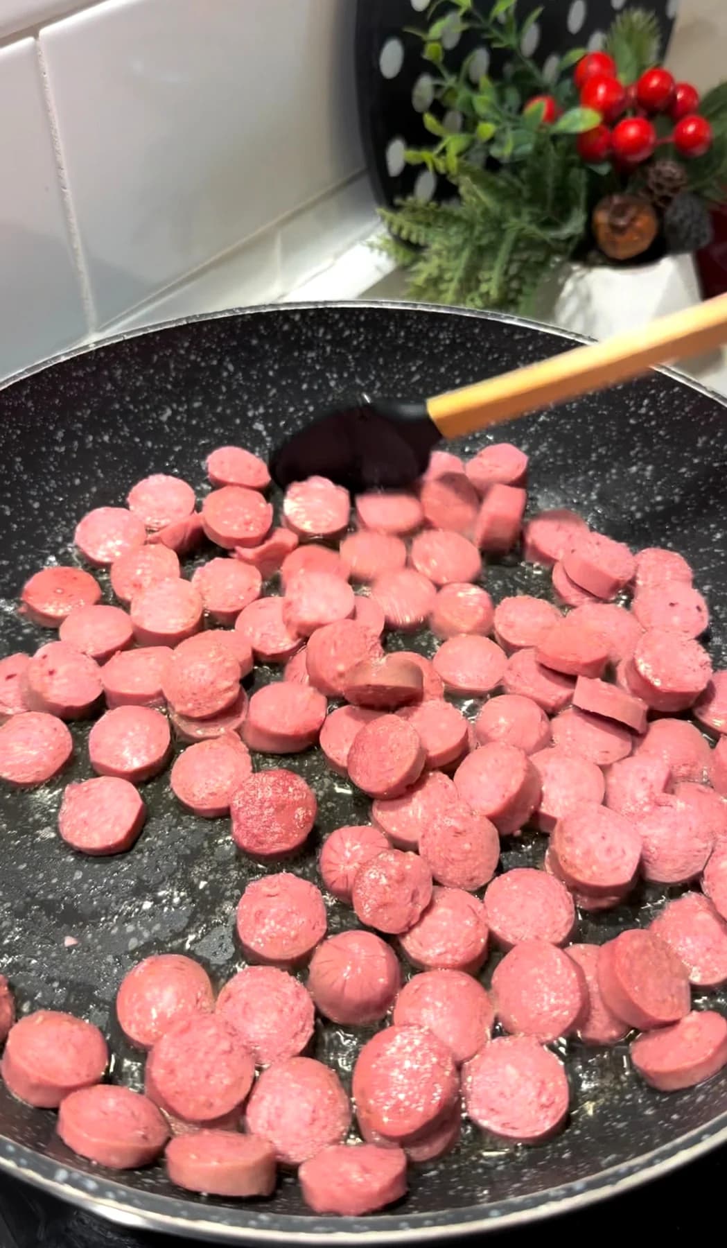 Sliced beef sausages cooking with tomato paste in a skillet