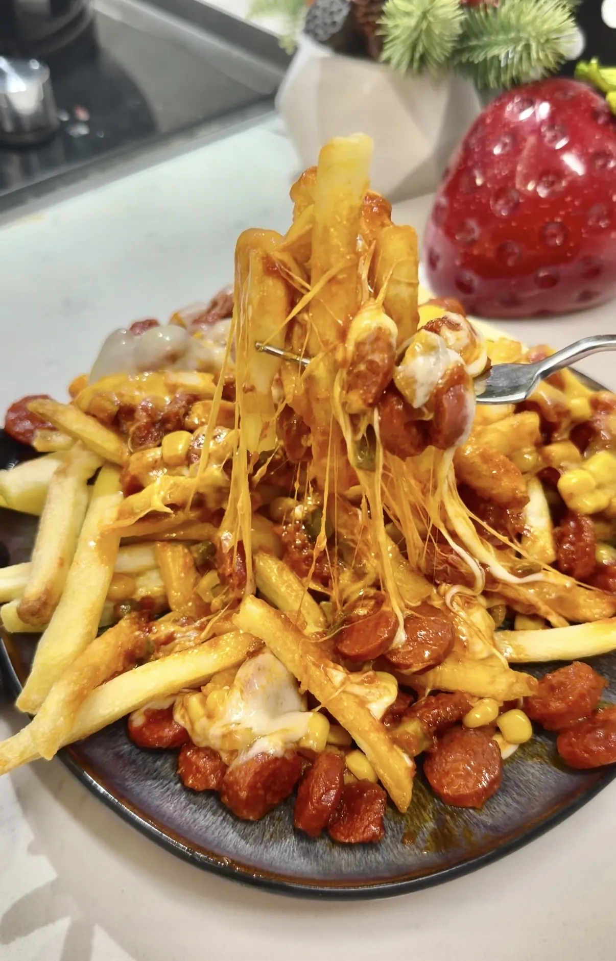 Melted cheese and saucy beef sausage being poured over French fries