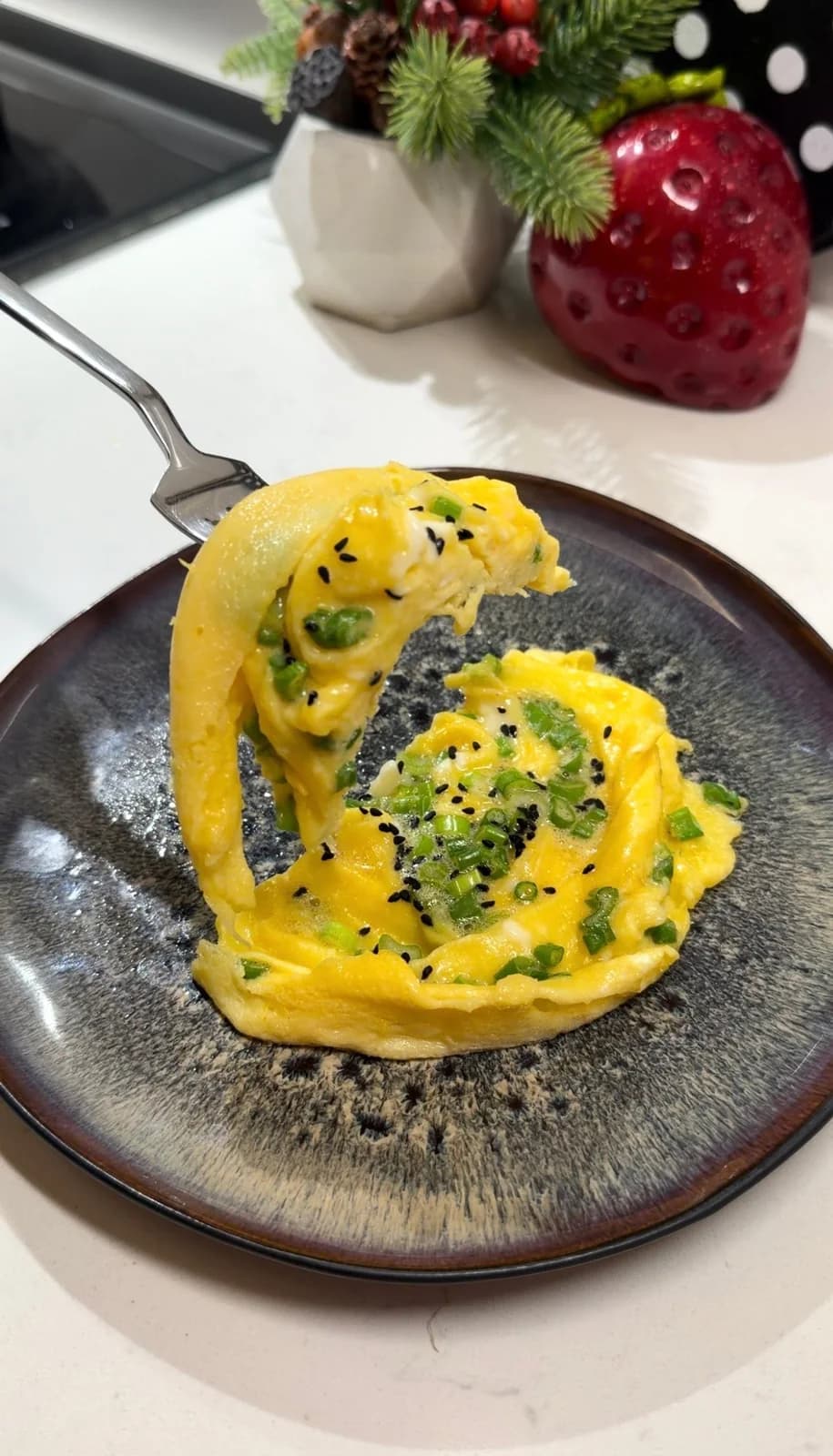 Soft Japanese rolled omelette with green onions and black cumin seeds ready to serve