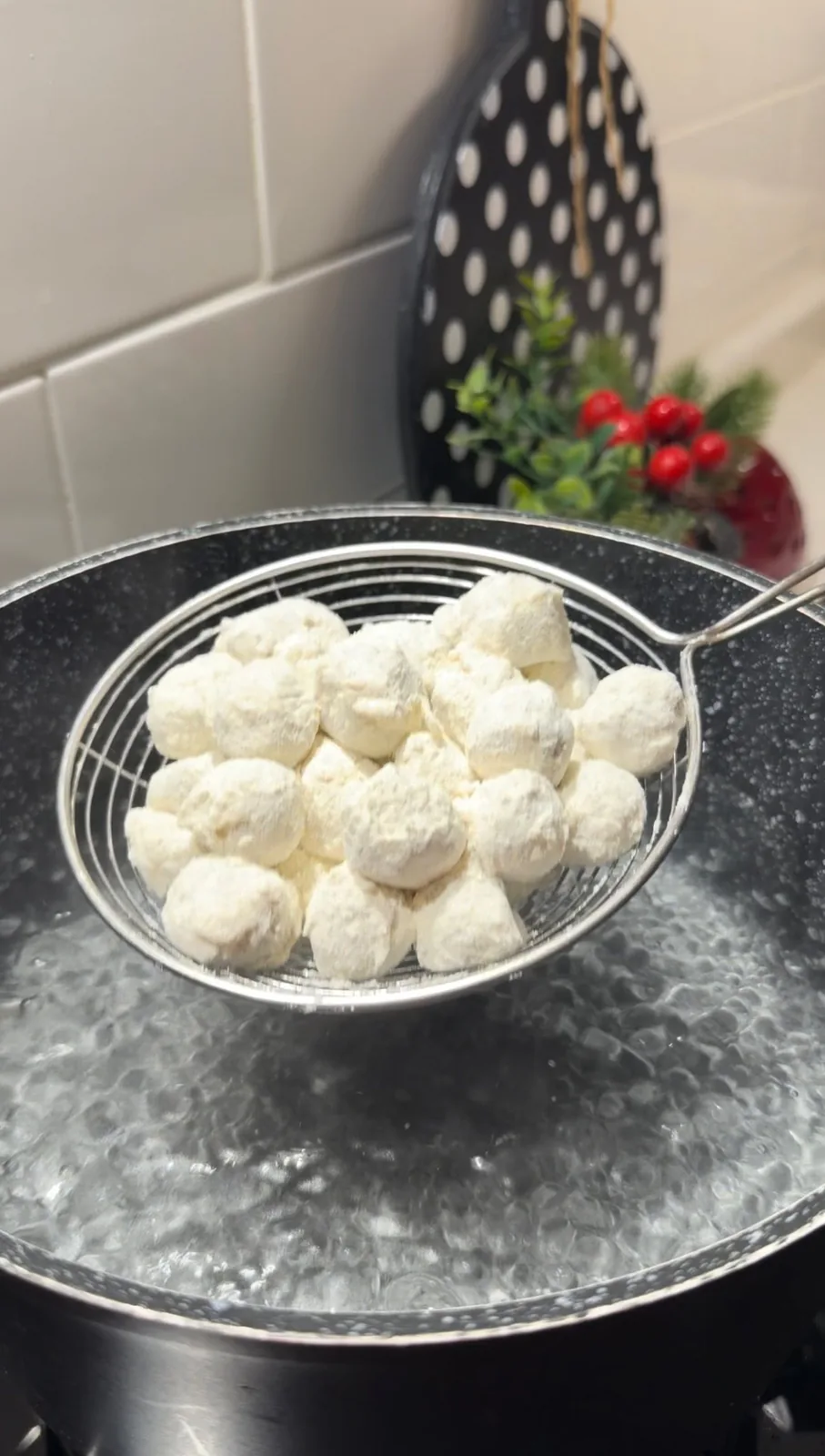 flour-coated Turkish beef dumplings being lowered into boiling water