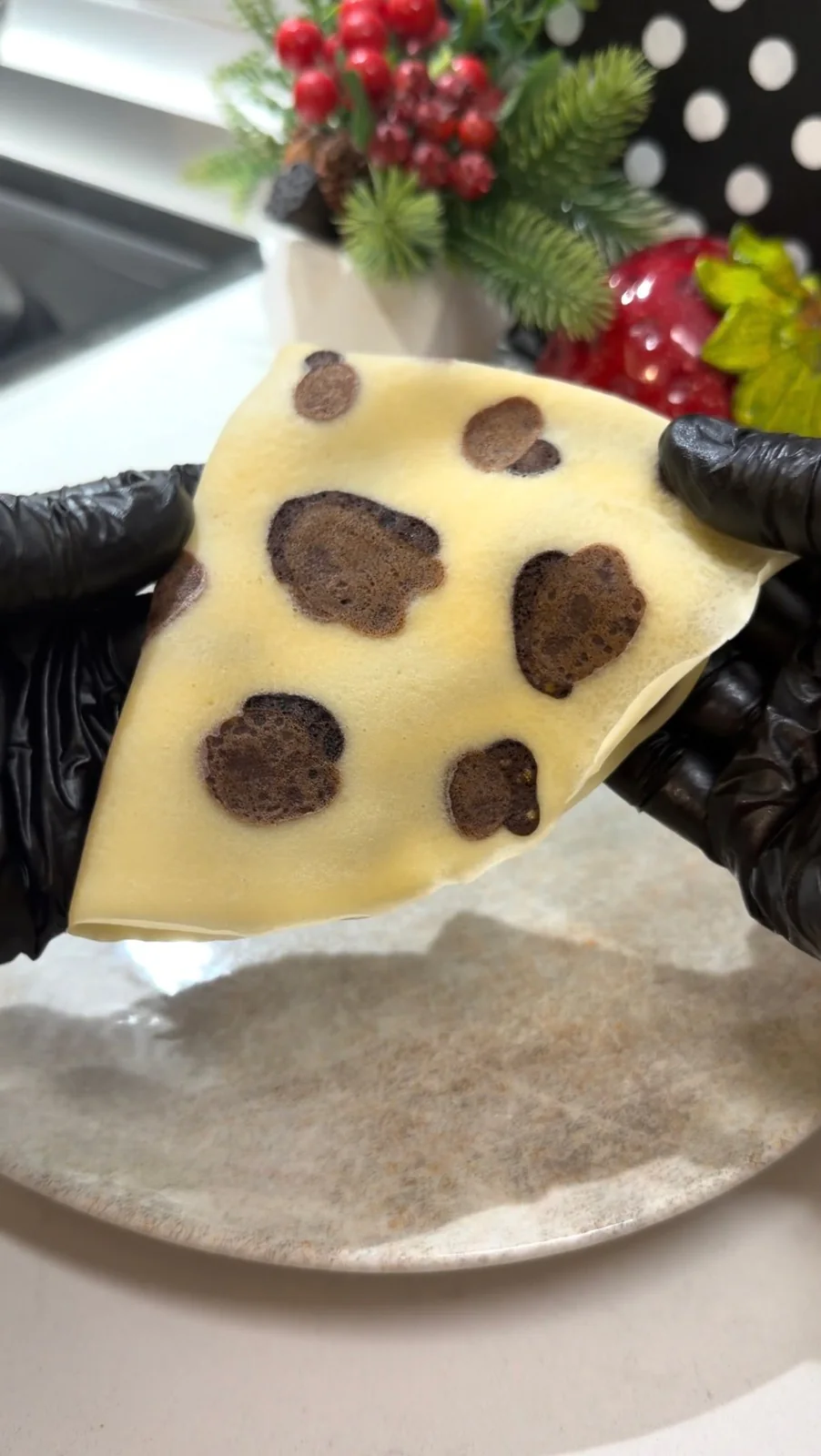 Finished homemade leopard pattern crepe held open to show the cocoa spots