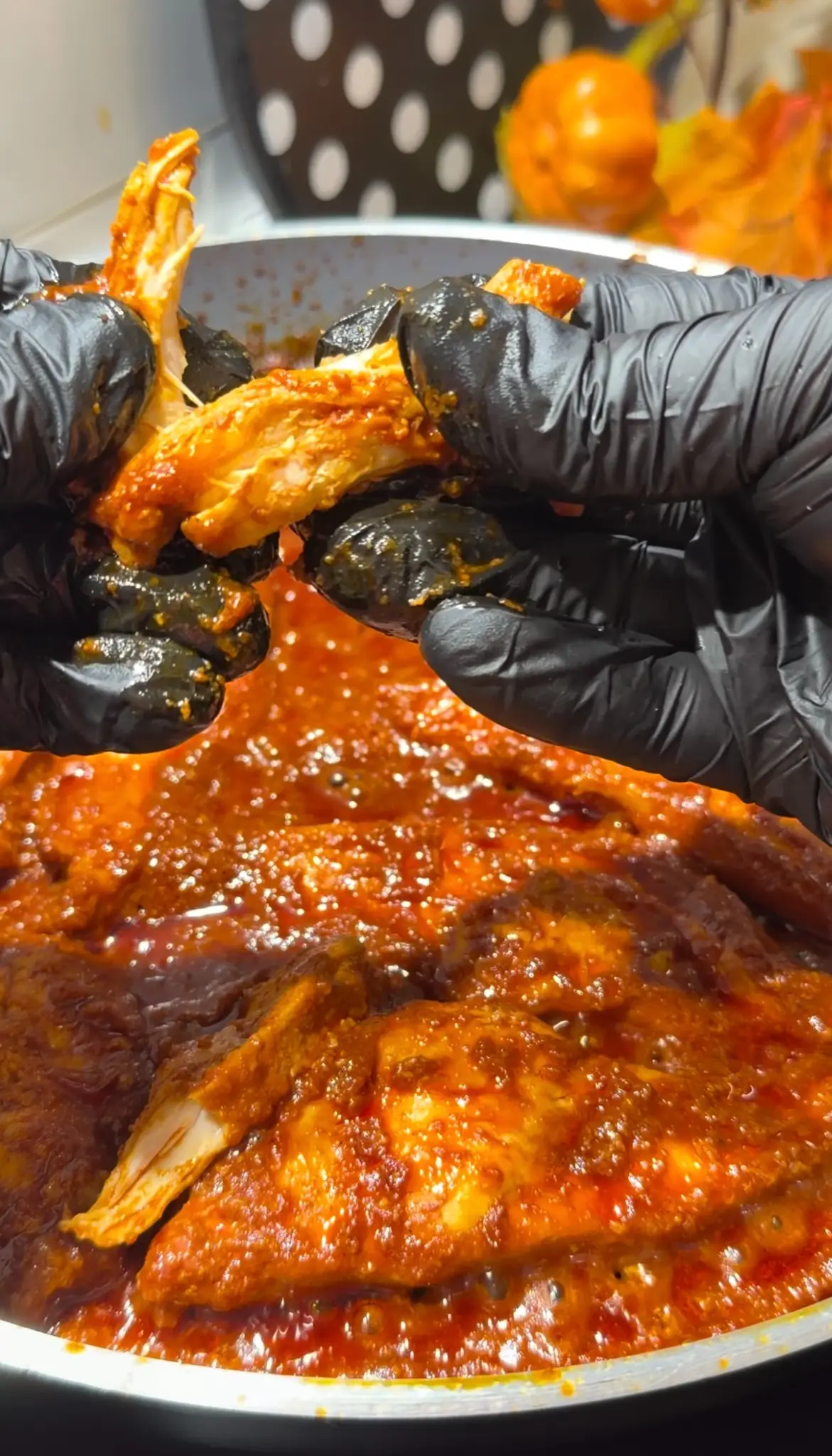 Tender chicken breast coated in rich tomato sauce being lifted from the skillet