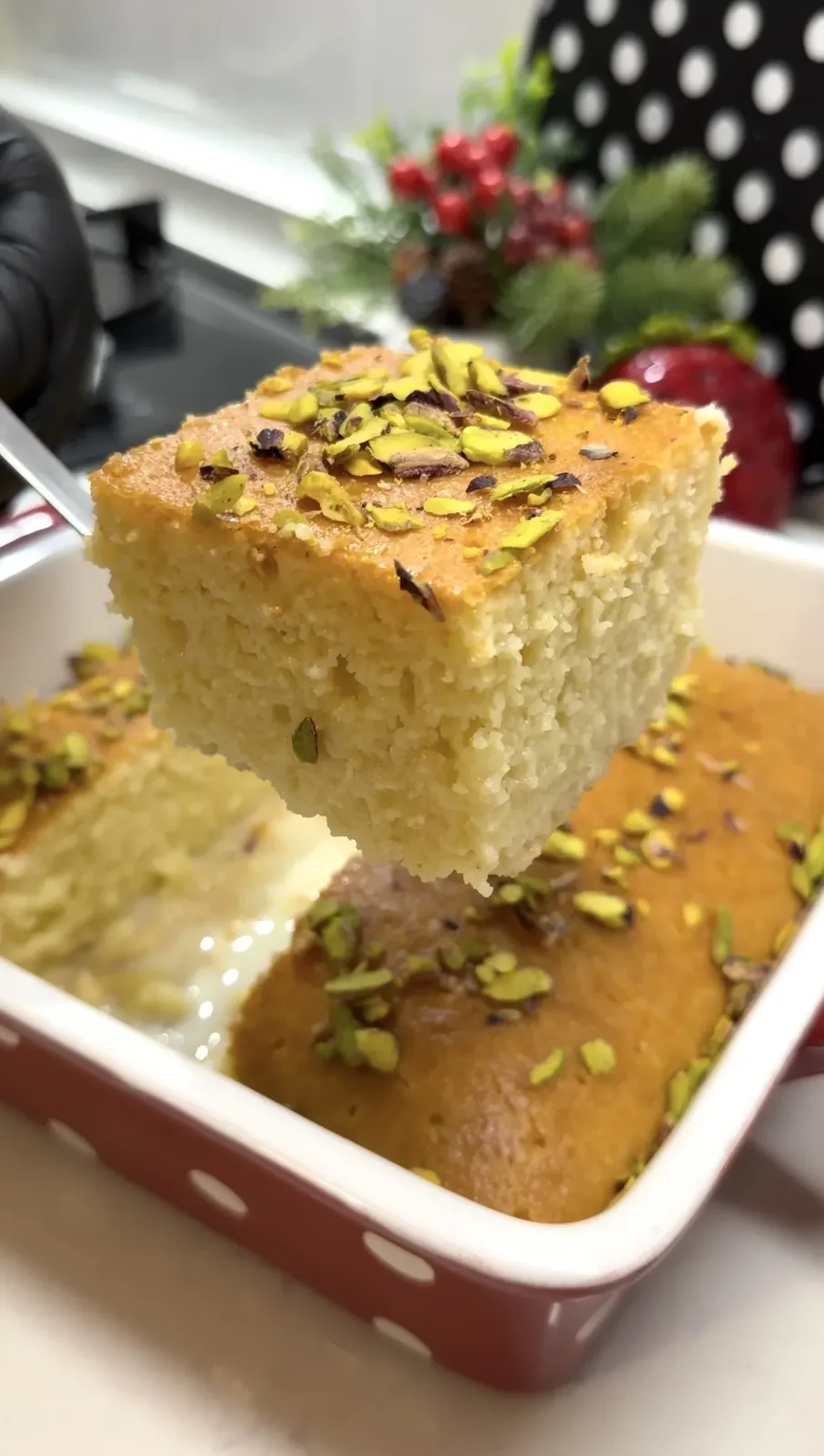 moist milk soaked semolina cake slice served with crushed pistachios