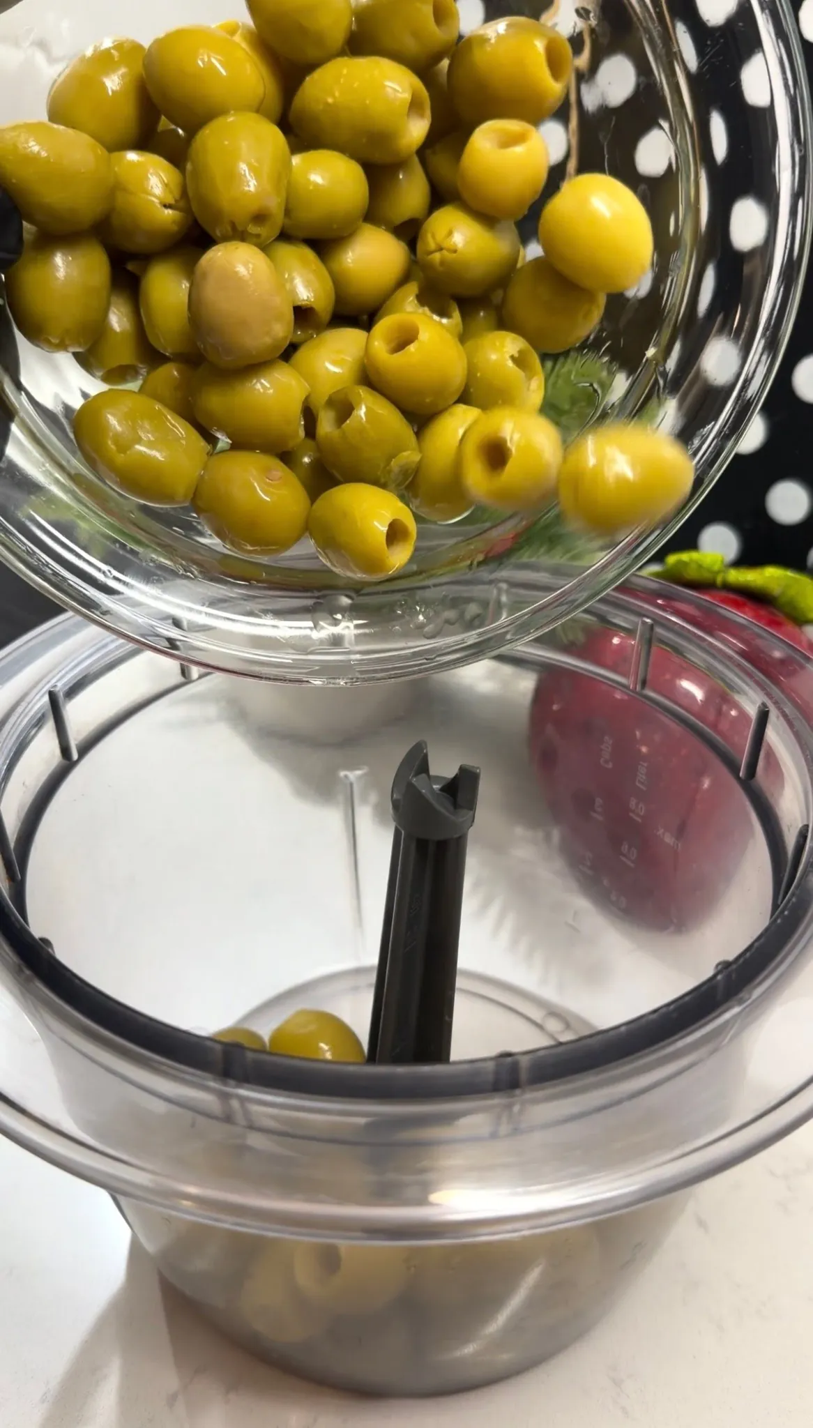 Green olives and feta cheese added to a food processor for olive spread