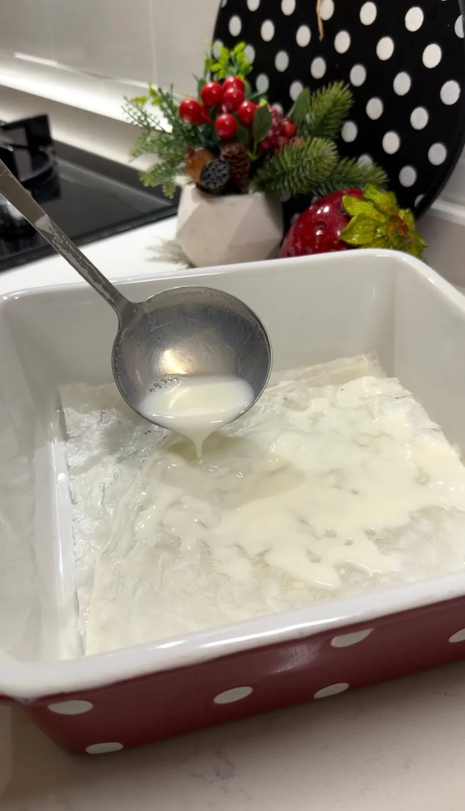warm milk poured over gullac sheets in a baking dish