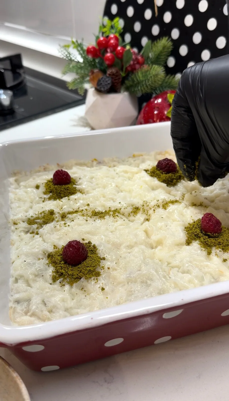 pistachio gullac decorated with ground pistachios and raspberries
