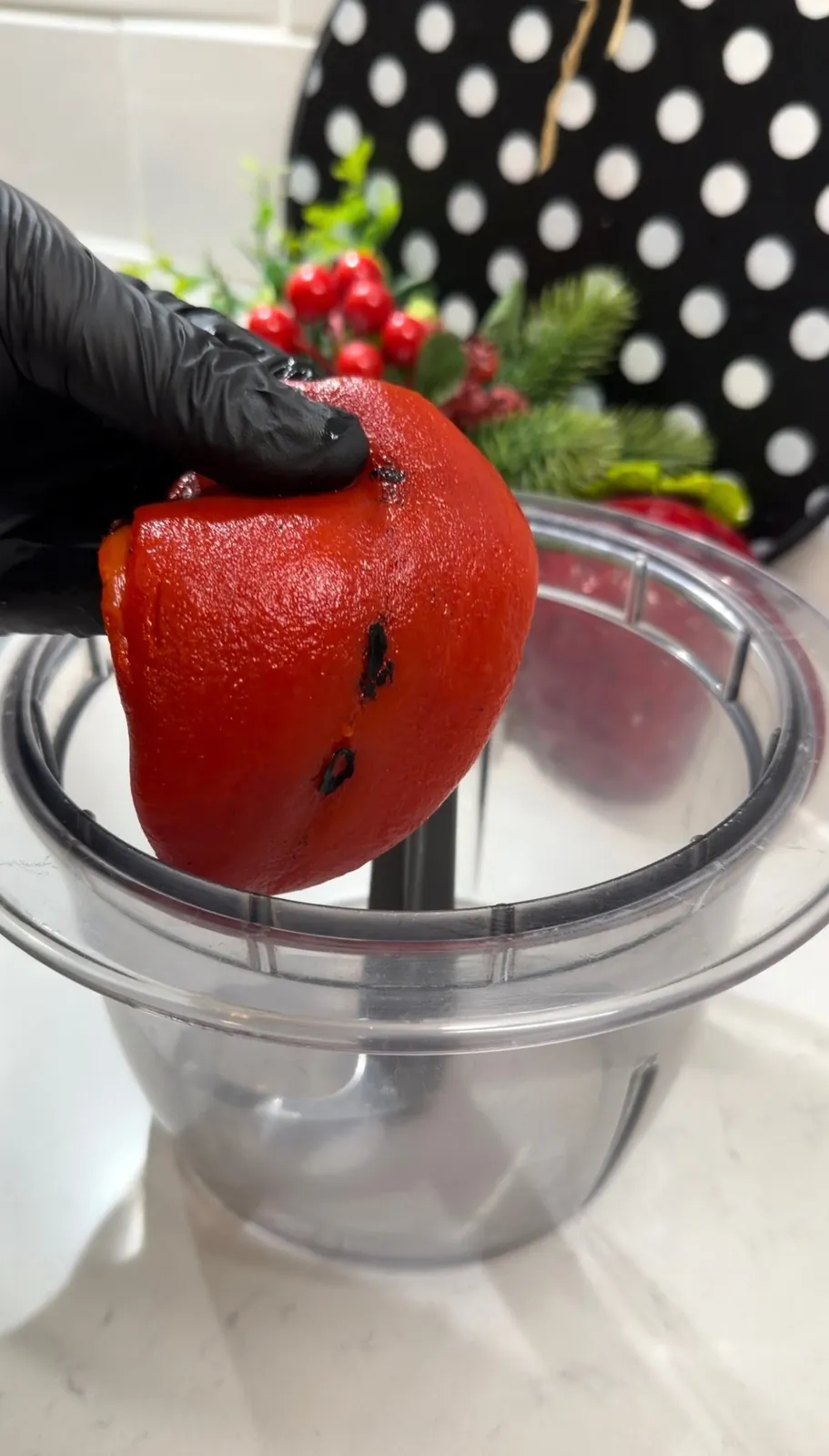 Roasted red peppers and feta cheese being added to a food processor