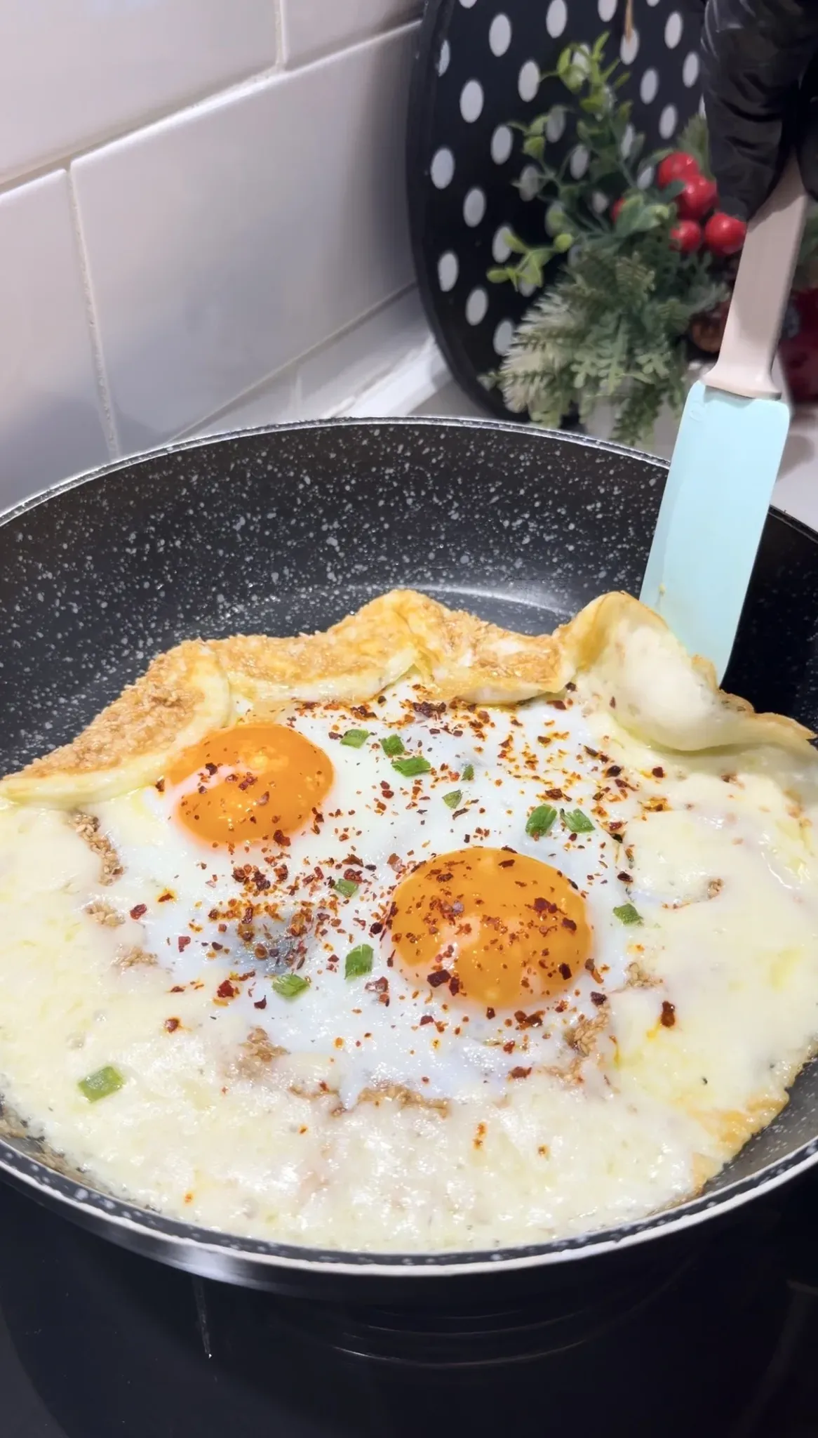Sesame crusted eggs with melted cheese red pepper flakes and green onions