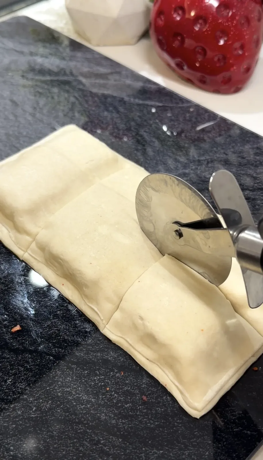 filled puff pastry being cut into small square bites