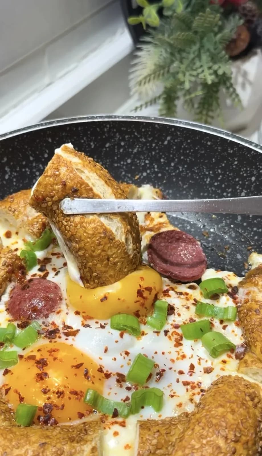 Turkish simit with eggs, sucuk and melted kashar cheese in a pan