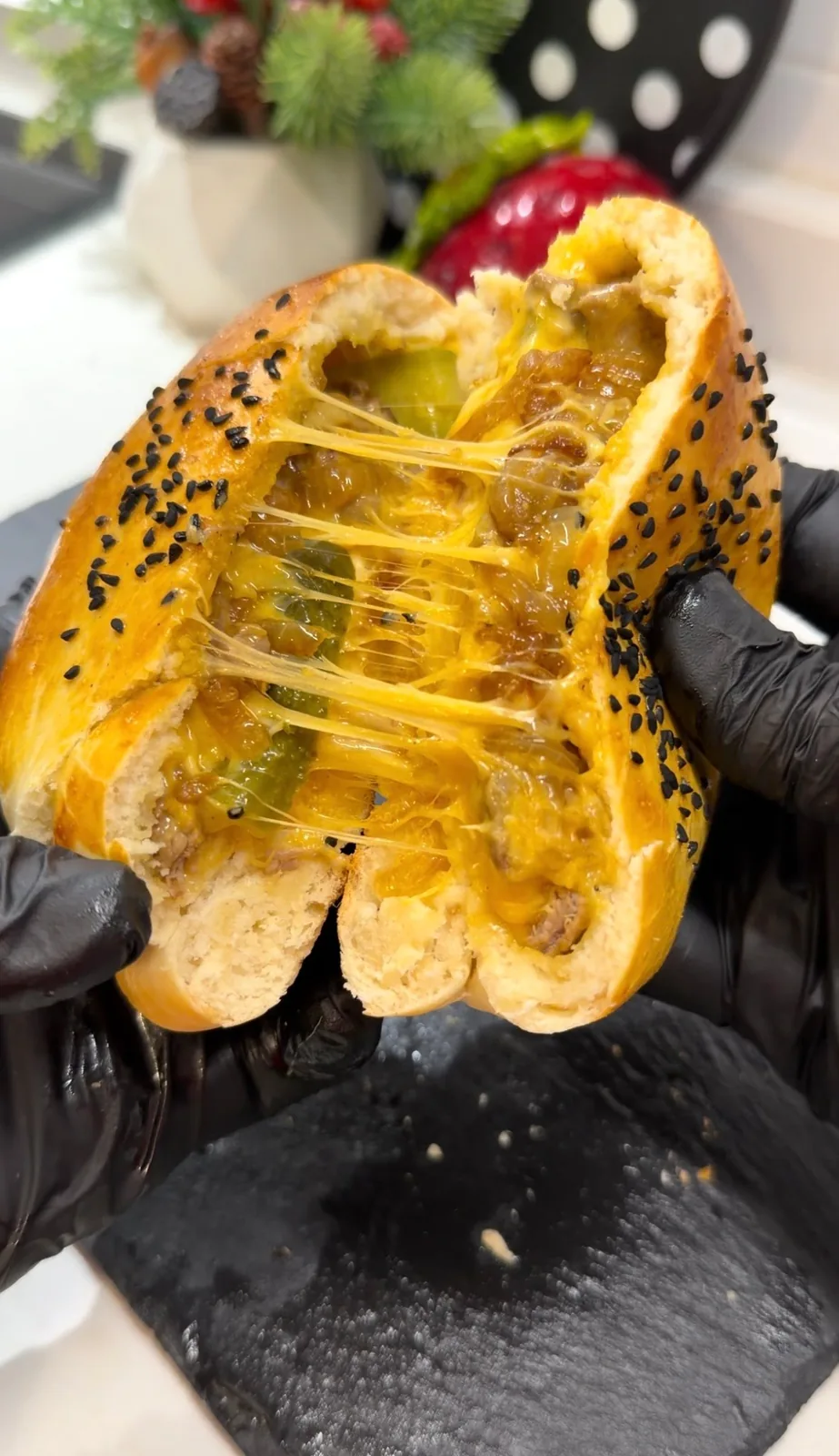 freshly baked stuffed burger bun pulled open with melted cheddar cheese and beef filling