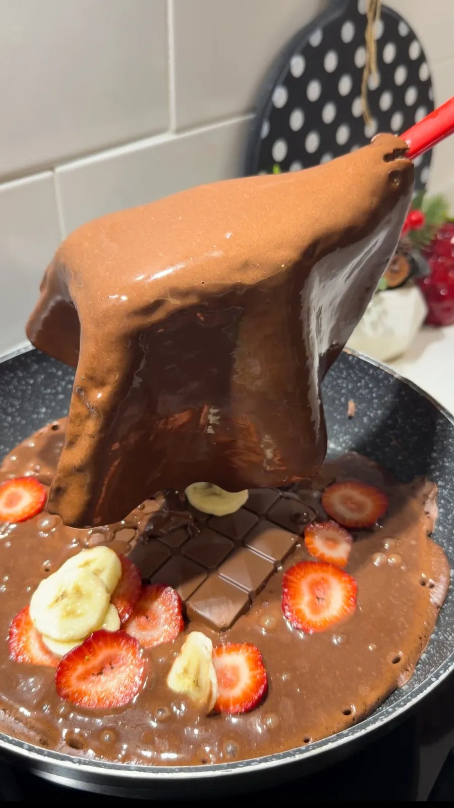 Chocolate stuffed pancake cut open with melted chocolate and fruit filling