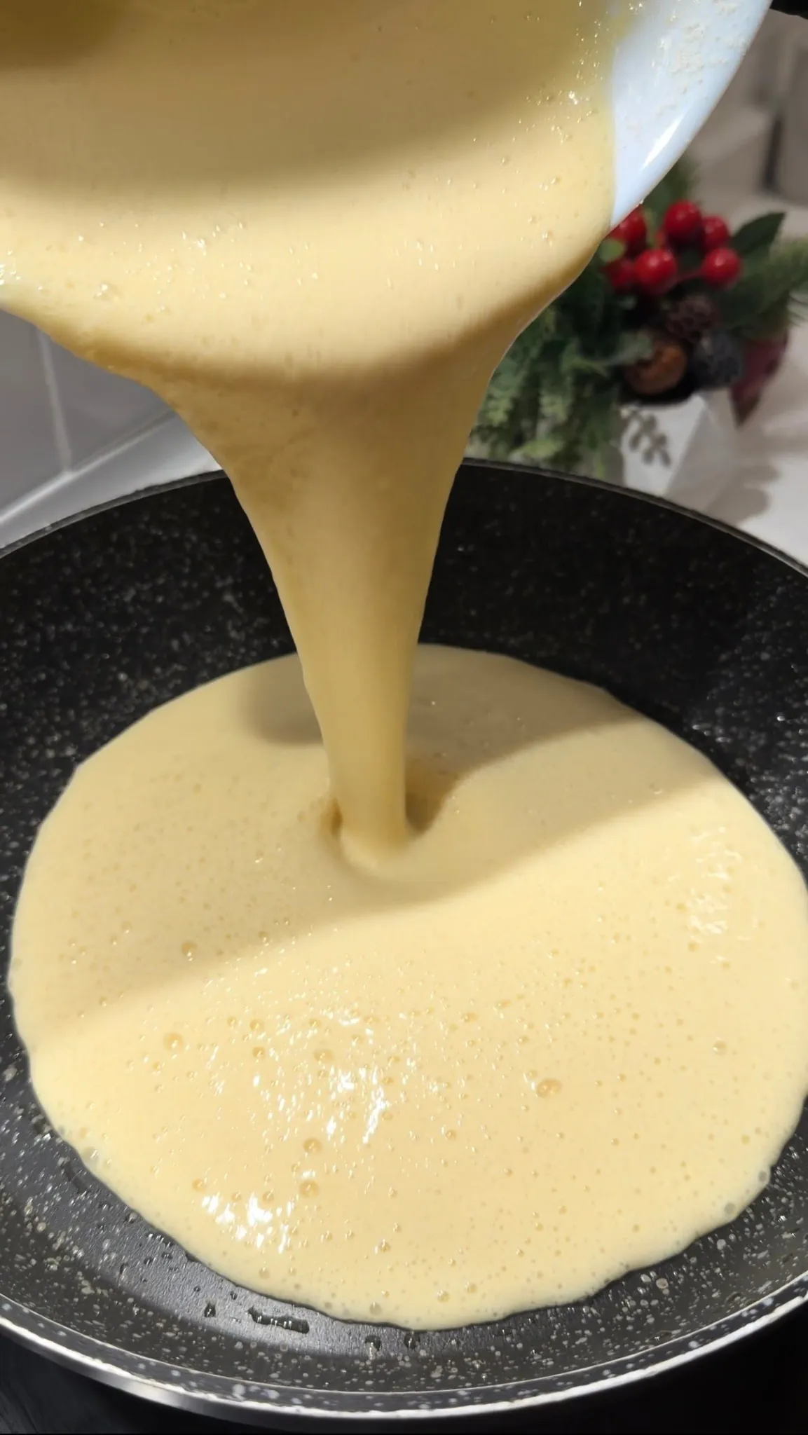 Homemade pancake batter being poured into a non-stick pan