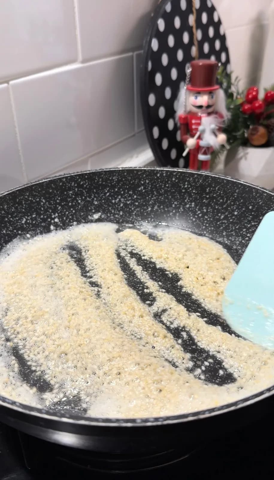 Sesame seeds toasting in melted butter in a frying pan
