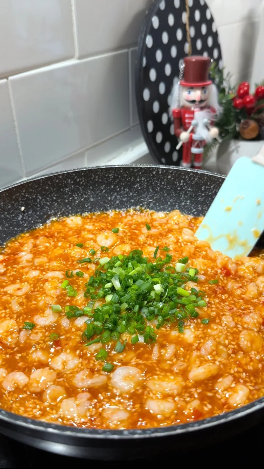 Sweet chili shrimp with sesame seeds and chopped green onions in a pan