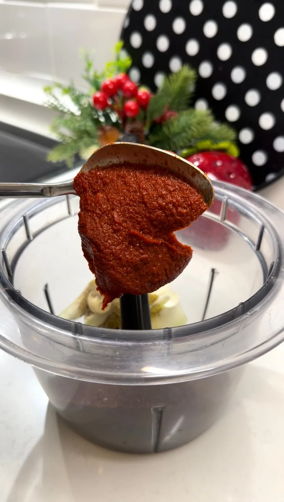 tomato paste, pepper paste, onion, garlic, and spices being added to a food processor for Turkish çiğ köfte