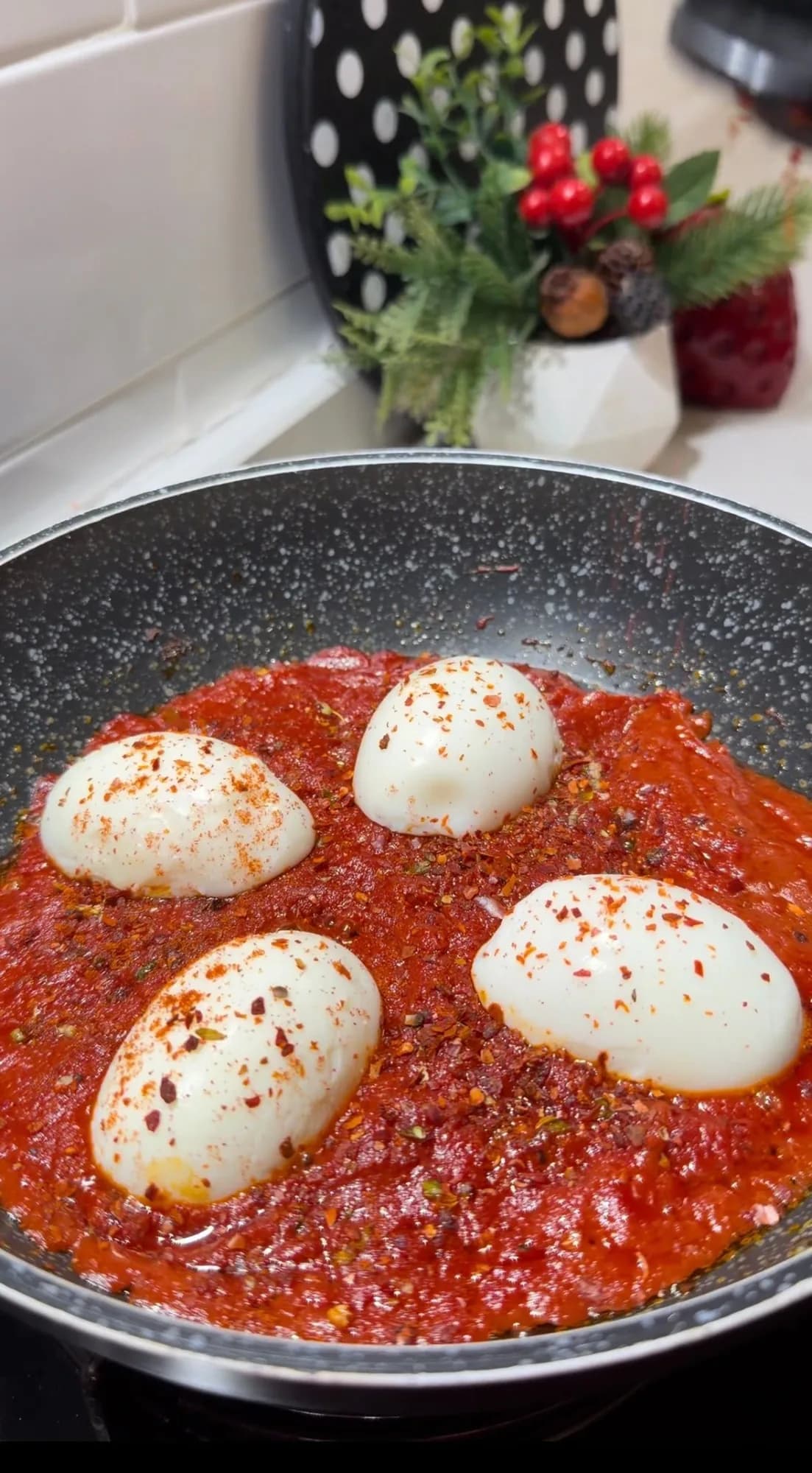 Boiled eggs cooking in Turkish tomato and pepper paste sauce