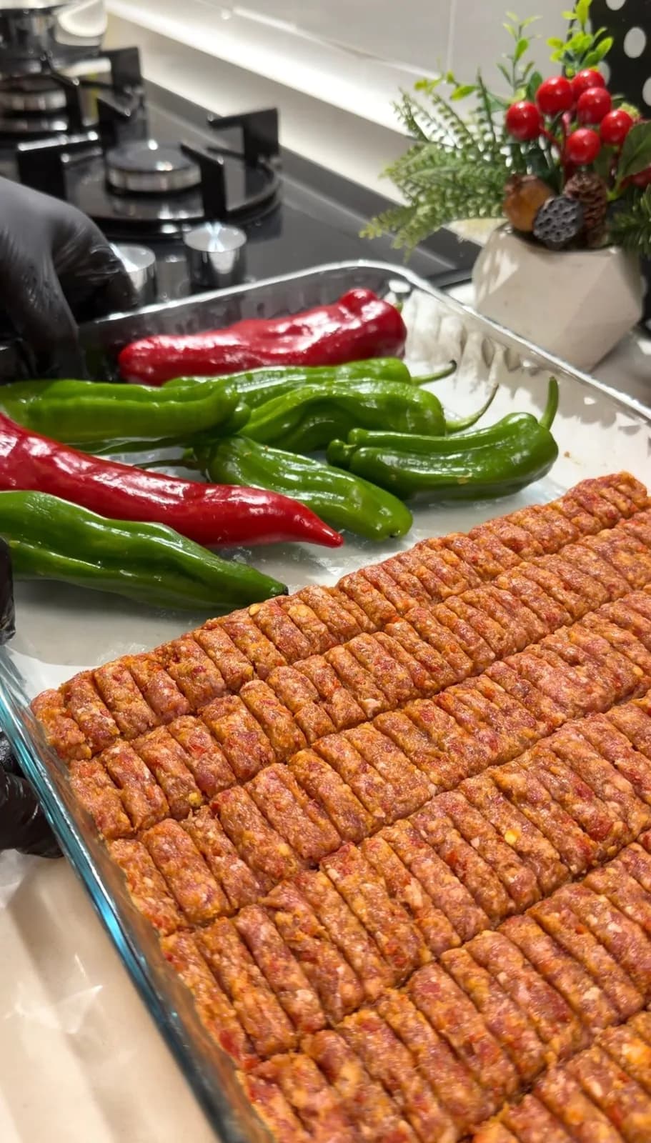 oven-baked Adana kebab with roasted red and green peppers in a baking dish