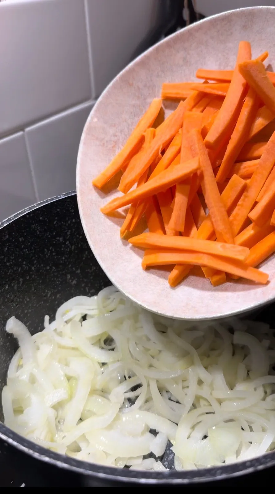 sliced onions and carrots cooking in a pot for Uzbek beef pilaf